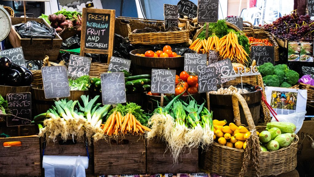 A table of fresh fruits and veggies for sale at a market