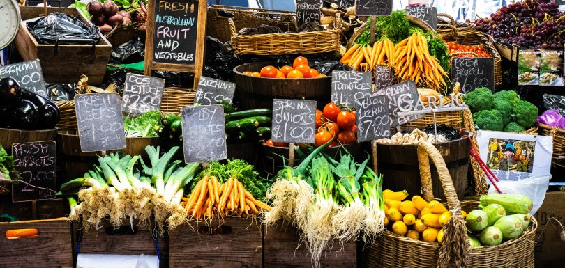 A table of fresh fruits and veggies for sale at a market