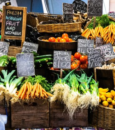 A table of fresh fruits and veggies for sale at a market
